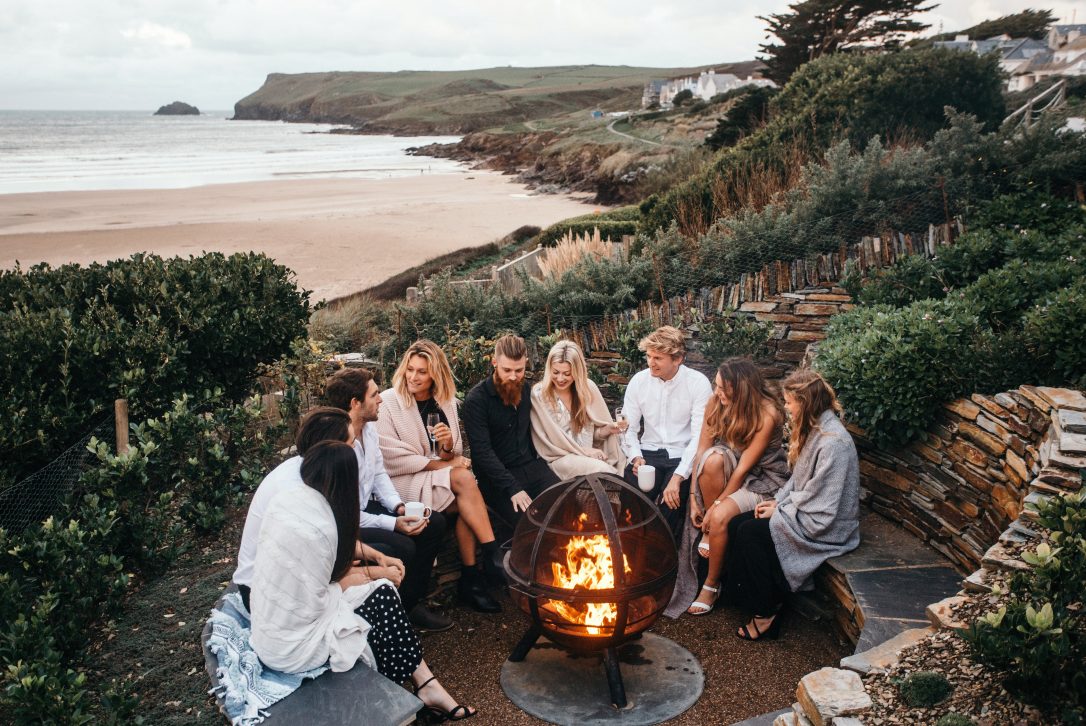 A group enjoying hot chocolates around the firepit at Carn Mar in Polzeath