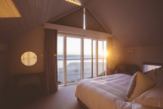 Sunset view from the master bedroom at Carn Mar, a self-catering holiday home in Polzeath, North Cornwall