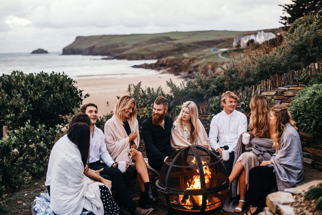 Group of friends around the fire pit at Carn Mar, a self-catering holiday home above Polzeath beach