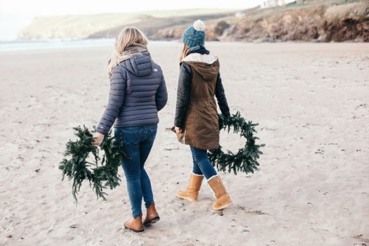 The Latitude50 team with fir Christmas wreaths on Polzeath beach