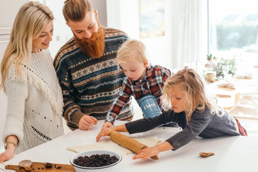 Family making mince pies in the kitchen at Compit, a self-catering holiday home in Polzeath, North Cornwall