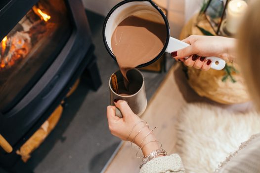 Pouring a cup of cocoa by the fire