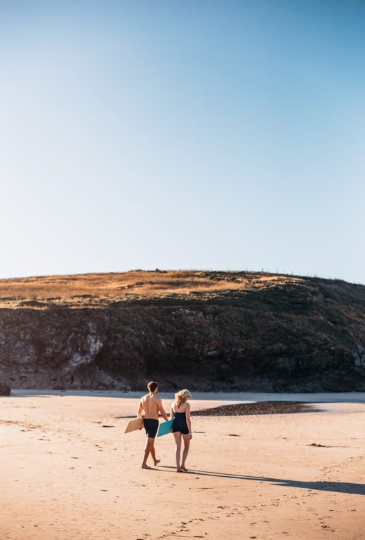 Couple bellyboarding at Baby Bay, Polzeath