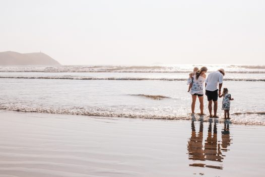 Family splashes in the sea at Polzeath, North Cornwall