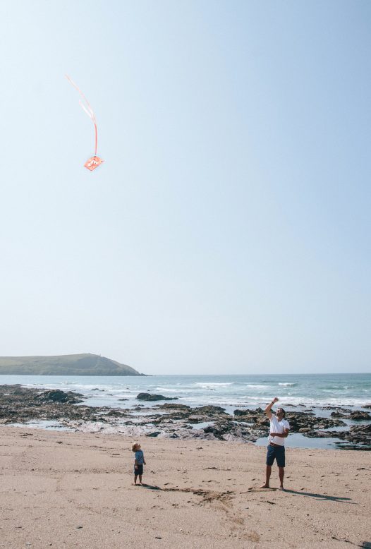 Family flying a kite on Greenaway beach, Polzeath, North Cornwall