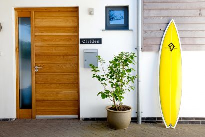 Front door and surf board at Clifden, a self-catering holiday cottage in New Polzeath, North Cornwall