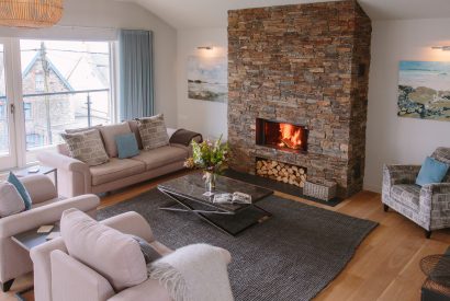 Living room with fire at Rosemar, a self-catering holiday home in New Polzeath, North Cornwall